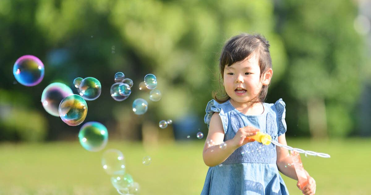 公園でシャボン玉を楽しむ２歳の女の子
